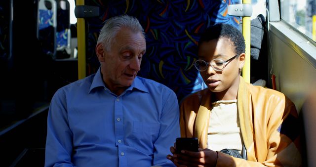 Elderly man and young woman sharing phone moment on public transport - Download Free Stock Images Pikwizard.com