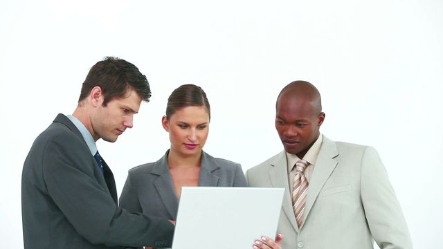 Diverse business team collaborating on a laptop in an office. Suitable for corporate presentations, teamwork illustrations, business meetings content, and workplace collaboration concepts.