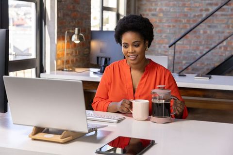 Professional Woman in Loft Office with Computer and Coffee
