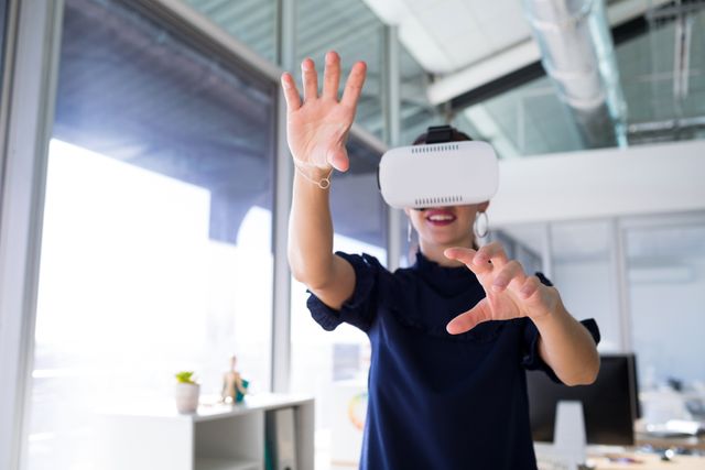 Female executive using virtual reality headset in office