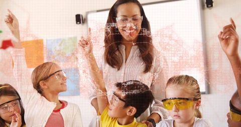 Elementary students conducting science experiment with teacher guiding group learning