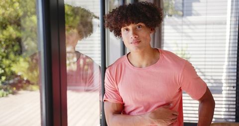 Thoughtful Young Man Relaxing by Window in Urban Environment