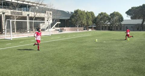 Youth Soccer Practice on School Field: Focus on Goal Shots