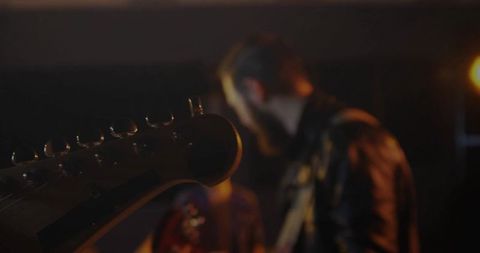 Guitarist on Lit Stage Focusing on Electric Guitar
