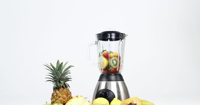 A blender is ready for use with various fruits inside, including strawberries and bell peppers, with copy space. Fresh ingredients are set to be blended, symbolizing healthy lifestyle choices and culinary preparation.