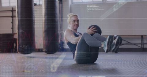 Woman Performing Russian Twist Exercise with Medicine Ball in Gym