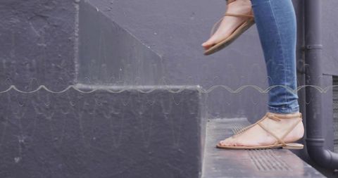 Stepping in Skinny Jeans and Sandals on Concrete Steps with Urban Style
