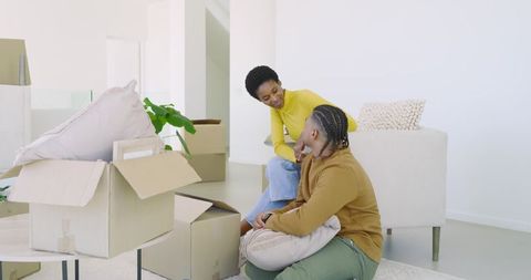 Friends Having Fun Unpacking Boxes in Modern Living Room