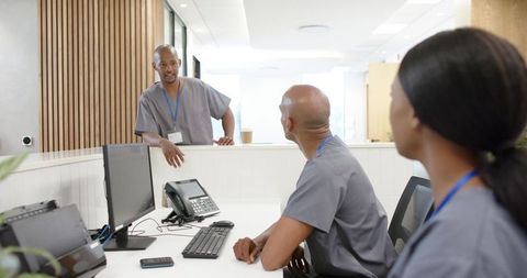 Nurse station teamwork: healthcare staff collaborating at modern clinic reception desk