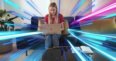 Young woman working on laptop at home with neon motion streaks conveying fast internet speed