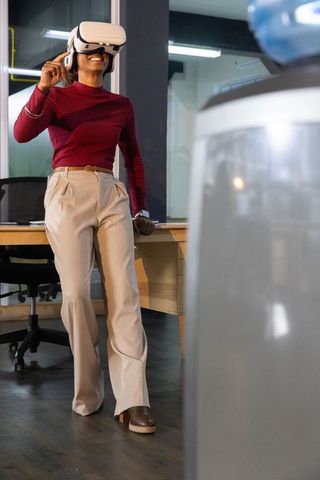 Indian professional experiencing virtual reality in modern office wearing white vr headset