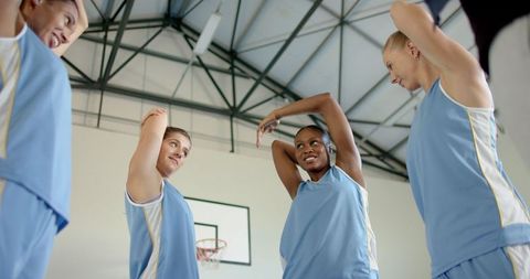Diverse Group of Basketball Players Stretching on Indoor Court