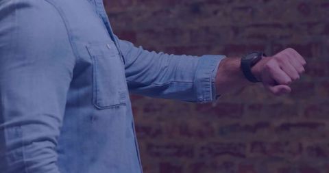 Man in casual denim focusing on smartwatch display