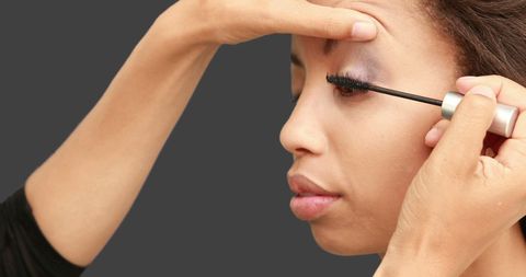 close-up focusing on skilled makeup artist enhancing model's eyelashes with mascara in a beauty session. perfect for beauty blogs, makeup tutorial content, cosmetics advertisements, or promotional materials related to the beauty industry. image exudes a sense of professionalism and elegance, ideal for capturing the artistry in makeup application techniques.