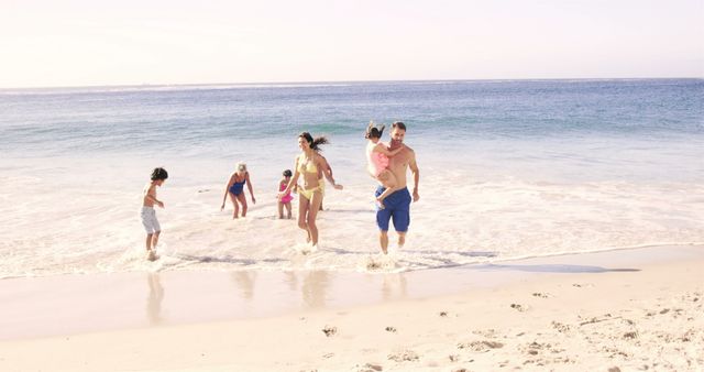 Cute family running out of the water on the beach