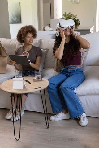 African american friends exploring virtual reality headset together in modern living room