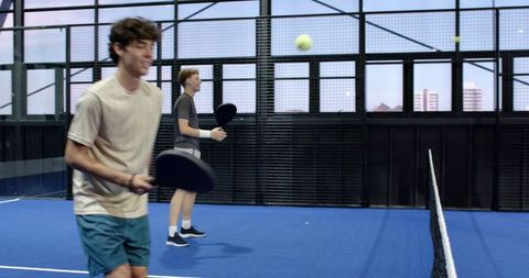Friends Enjoying Padel Game on Indoor Court