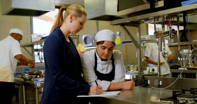 Chef receiving instructions from supervisor in a professional kitchen - Download Free Stock Images Pikwizard.com