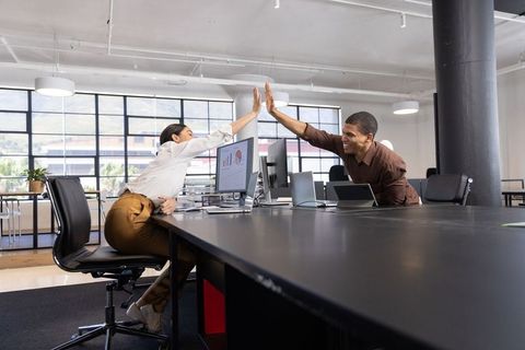 Colleagues Celebrating Success with High Five in Modern Office