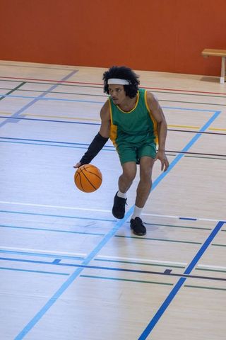 Athlete Dribbling Basketball in Gym, Focus on Speed and Skill