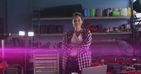 Confident Female Mechanic Standing in Auto Workshop with Laptop
