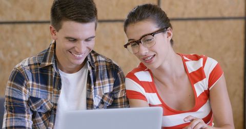 Young Adult Pair Collaborating Cheerfully on Laptop - Download Free Stock Images Pikwizard.com