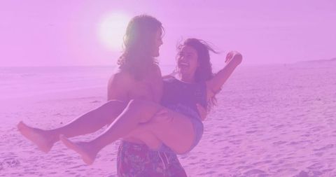 Joyful Couple Enjoying Sunset Stroll on Beach