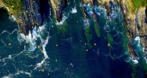 Aerial view of majestic coastline with artistic gold stars