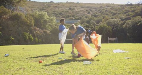 Youthful Volunteers Cleaning Up Sports Field Outdoors