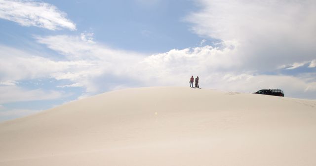 Couple Standing on Desert Sand Dune with Car Under Blue Sky - Download Free Stock Images Pikwizard.com