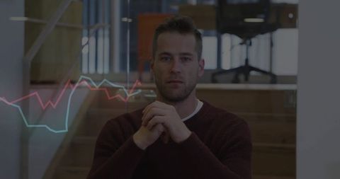 Businessman analyzing trends with digital charts in modern office