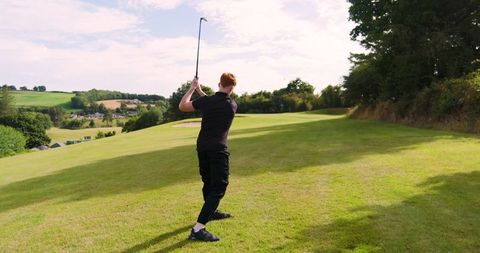 Teenager Swinging Golf Club on a Idyllic Fairway