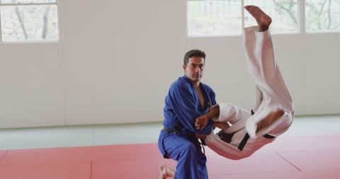 Two Male Judo Fighters in Action on Red Mats at Sunlit Gym - Download Free Stock Images Pikwizard.com