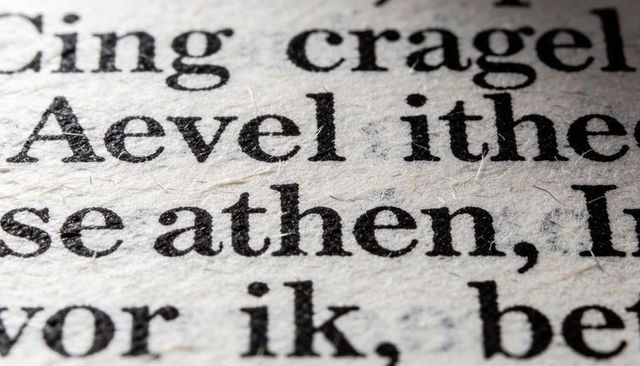Macro revealing textured serif typography on fibrous paper with ink dot and spread detail
