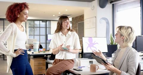 Diverse Female Colleagues Engaging in an Office Discussion