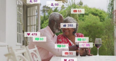 Laughing senior couple sharing intimate porch moment with social media notifications