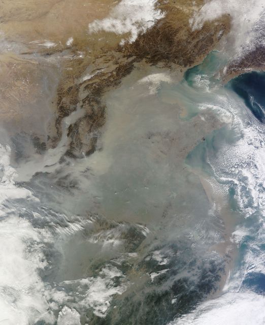The skies over northern China were shrouded with a thick haze in late December, 2013. The Moderate Resolution Imaging Spectroradiometer (MODIS) aboard the Terra satellite captured this true-color image on December 23.  The dense, gray haze obscures almost all the land and much of the coastal waters from view south and east of the Taihang Mountains. Clearer air covers the region north of the mountains, although fingers of haze roll through most river valleys. The cities of Beijing and Hebei, both west of the Bohai Sea are complete enshrouded.  By December 24 the smog levels in some area exceeded World Health Organization-recommended levels by 30 times, according to Bloomberg News. The concentration of PM2.5, which are fine air particulates, were reported at 421 micrograms per cubic meter at 2 p.m. near Tiananmen Square in Beijing, while levels were 795 in Xi’an and 740 in Zhengzhou. The World Health Organization (WHO) recommends 24-hour exposure to PM2.5 concentrations no higher than 25 micrograms per cubic meter.  While not the sole cause of haze and pollution, the use of coal as a very cheap energy source adds to the problem, particularly north of the Huai River. Prior to 1980, the government policy provided free coal for fuel boilers for all people living north of the Huai River. The widespread use of coal allows people in the north to stay warm in winter, but they have paid a price in air quality.  According to Michael Greenstone, a Professor of Environmental Economics at Massachusetts Institute of Technology (MIT), whose research team published a paper on sustained exposure to air pollution on life expectancy in the region, air pollution, as measured by total suspended particulates, was about 55% higher north of the Huai River than south of it, for a difference of around 184 micrograms of particulate matter per cubic meter. The research, published in Proceedings of the National Academy of Sciences in July, 2013, also noted life expectancies were about 5.5 years lower in the north, owing to an increased incidence of cardiorespiratory mortality.  Air pollution is an on-going issue for the government of China, and Beijing’s Five-Year Clean Air Action Plan aims to reduce overall particle density by over 25 percent on the PM2.5 scale by 2017, and also takes aim at shutting down all coal-burning plants.  Credit: NASA/GSFC/Jeff Schmaltz/MODIS Land Rapid Response Team   <b><a href="http://www.nasa.gov/audience/formedia/features/MP_Photo_Guidelines.html" rel="nofollow">NASA image use policy.</a></b>  <b><a href="http://www.nasa.gov/centers/goddard/home/index.html" rel="nofollow">NASA Goddard Space Flight Center</a></b> enables NASA’s mission through four scientific endeavors: Earth Science, Heliophysics, Solar System Exploration, and Astrophysics. Goddard plays a leading role in NASA’s accomplishments by contributing compelling scientific knowledge to advance the Agency’s mission.  <b>Follow us on <a href="http://twitter.com/NASA_GoddardPix" rel="nofollow">Twitter</a></b>  <b>Like us on <a href="http://www.facebook.com/pages/Greenbelt-MD/NASA-Goddard/395013845897?ref=tsd" rel="nofollow">Facebook</a></b>  <b>Find us on <a href="http://instagram.com/nasagoddard?vm=grid" rel="nofollow">Instagram</a></b>
