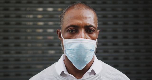 An African American man dons a face mask in the city to protect against pollution and COVID-19. - Download Free Stock Photos Pikwizard.com