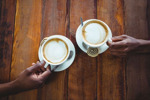 Couple hand holding cup of coffee in cafeteria