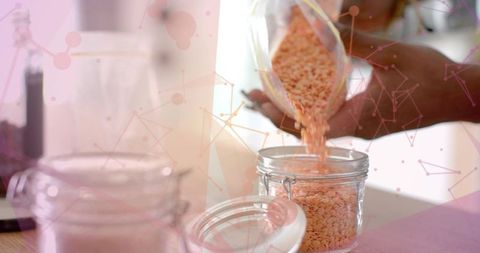 Pouring orange lentils into jar for kitchen organization