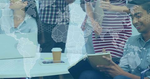 Global team collaborating during strategy session with world map overlay and notebooks