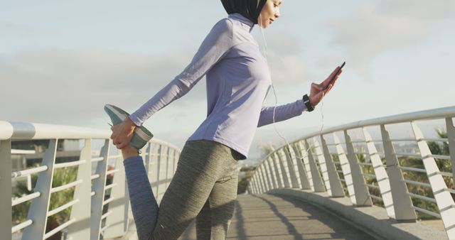 Female Runner Stretching on Urban Bridge While Checking Phone - Download Free Stock Images Pikwizard.com