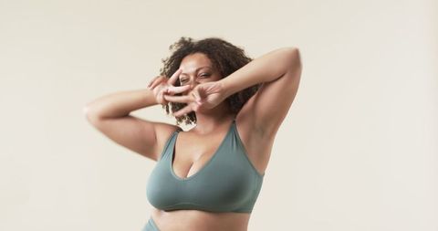 Confident Curly Hair Plus Size Woman Smiling in Sportswear
