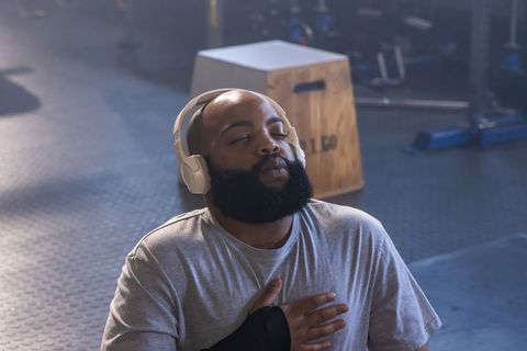 Bearded african american man recovering after intense workout wearing headphones
