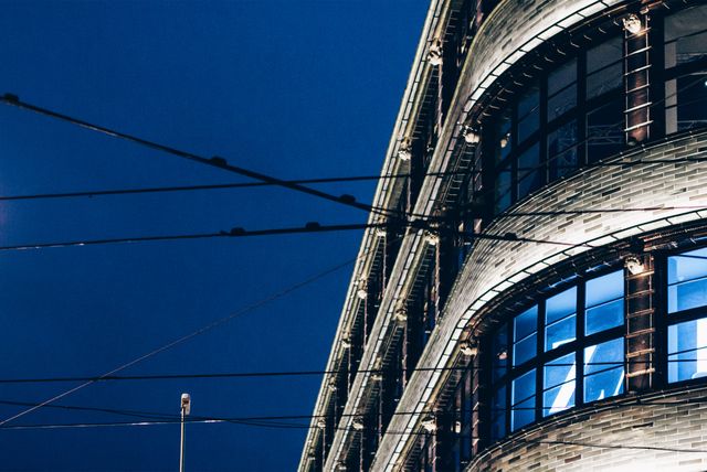 Modern Building Corner at Night with Blue Skies and Illuminated Windows - Download Free Stock Images Pikwizard.com