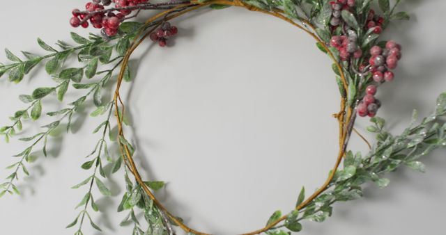 Handmade Christmas wreath featuring evergreen branches and red berries. Perfect for holiday home decor, crafting projects, and seasonal greeting cards. Use as wall or door decoration to evoke a festive, rustic charm for the winter season.