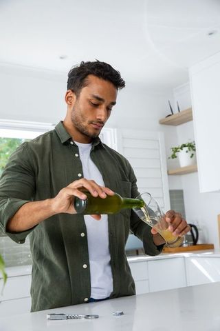 Man pouring beverage in modern kitchen for healthy lifestyle