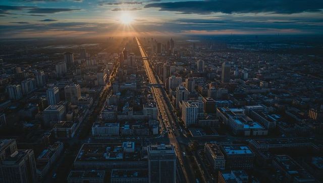 Sunset Boulevard Slicing City Grid Toward Sunlit Towering Downtown Skyline