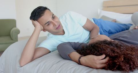 Happy Diverse Gay Couple Relaxing on Bed at Home