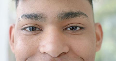 Close-up african american male smiling showing skin texture under soft window light headshot